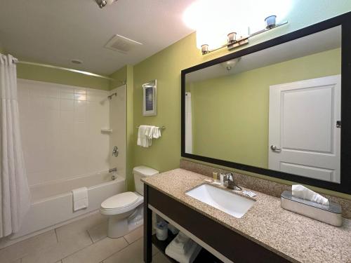 a bathroom with a sink and a toilet and a mirror at Sleep Inn & Suites Altoona North in Altoona