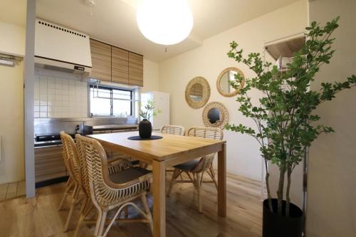 a dining room with a wooden table and chairs at ウィズ八王子レジデンス 102 in Hachioji