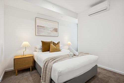 Un dormitorio blanco con una cama y una mesita de noche. en CANN507 - Cannington Comfort, en Perth