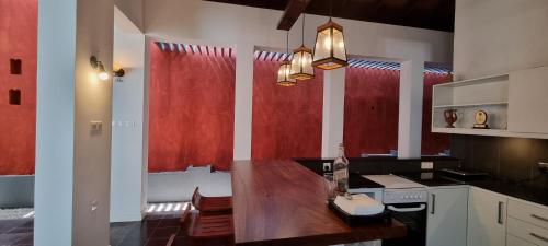 a kitchen with a wooden table and red curtains at Villa Red, Battaramulla in Sri Jayewardenepura Kotte