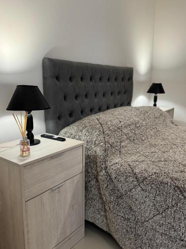 a bedroom with a large bed with a black headboard at corazón de Maipú in Maipú