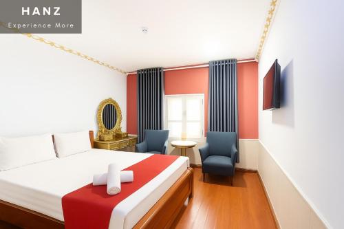 une chambre avec un lit et deux chaises dans l'établissement S79 Crowne Bui Vien, à Hô-Chi-Minh-Ville