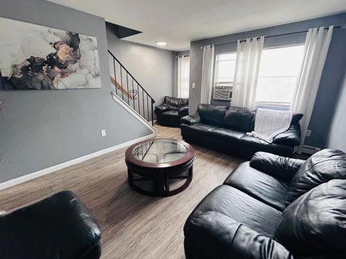 a living room with a leather couch and a table at So sweet so stylish in Elizabeth