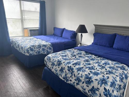 een slaapkamer met 2 bedden met blauwe en witte lakens bij So sweet so stylish in Elizabeth