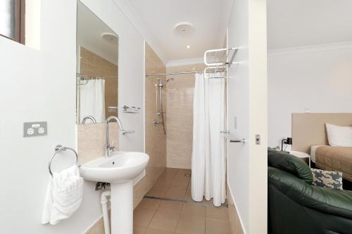 a small bathroom with a sink and a shower at Boggabri Motel in Boggabri