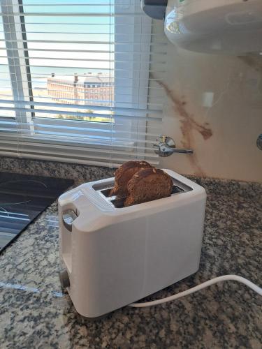 a white toaster on a counter with a cookie in it at Vista y confort - Cerca de todo in Mar del Plata