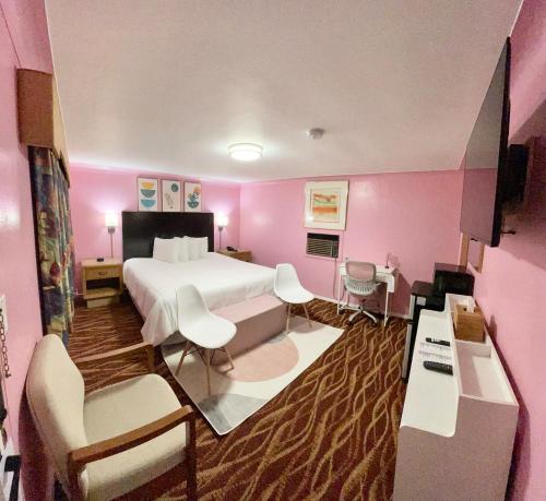 a hotel room with a large bed and pink walls at Best Motel Bowling Green in Bowling Green