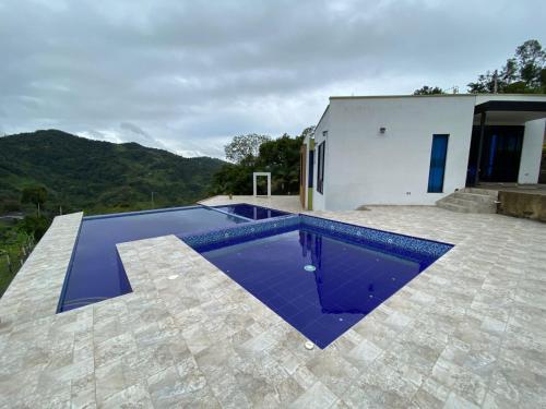 a swimming pool in front of a house at Finca Villa Gabriela in Vergara