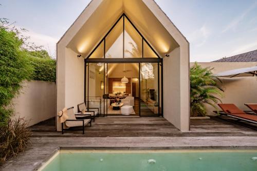 a home with a swimming pool and a house at Usawa Villa Nyanyi in Munggu