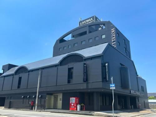 a black building with a sign on top of it at HOTEL LiVEMAX Toyooka in Toyooka