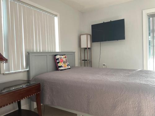 een slaapkamer met een bed en een televisie aan de muur bij 海湾景观休闲独立屋可垂钓靠近达利博物馆 in St Petersburg