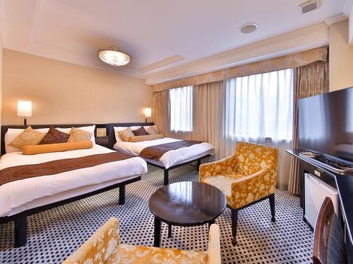 a hotel room with two beds and a flat screen tv at APA Hotel Tsukiji Ekiminami in Tokyo