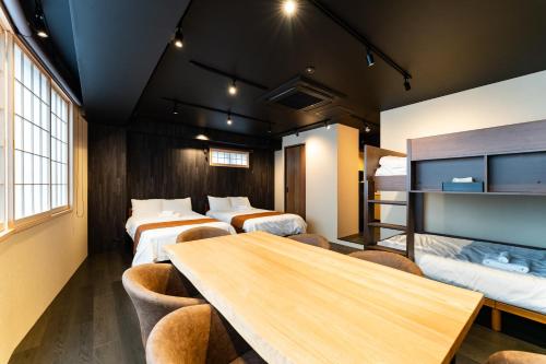a room with four beds and a table and chairs at Koala Inn Ueno in Tokyo