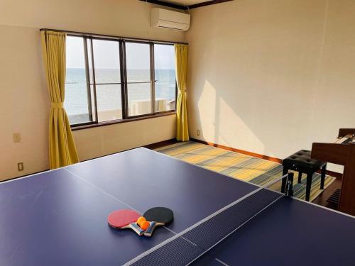 a ping pong table in a room with a beach at DAISEN UMIHOTARU Entire house in Daisen