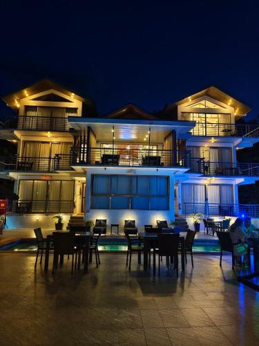 a building with tables and chairs in front of it at night at AV Suites in Puerto Galera