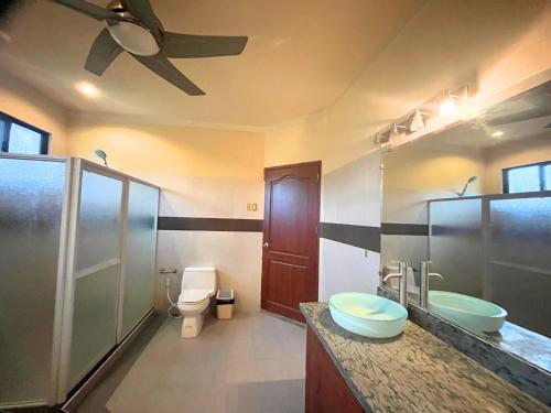 a bathroom with two sinks and a toilet at Casaroyal Beachfront Siquijor in Siquijor