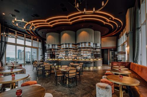 a restaurant with tables and chairs and a bar at Four Points by Sheraton Auckland in Auckland