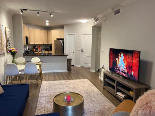 a living room with a couch and a tv on a wall at Spacious 1bdrm apartment 10 mins to Cedars-Sinai by car FREE Parking, King bed in Los Angeles