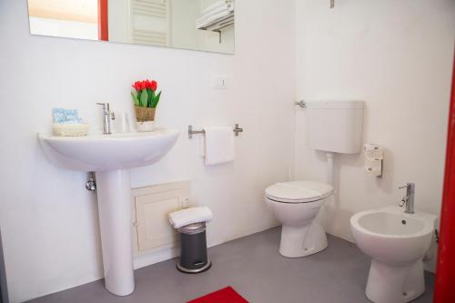 uma casa de banho branca com um lavatório e um WC em Guest House del Conte em Fondi