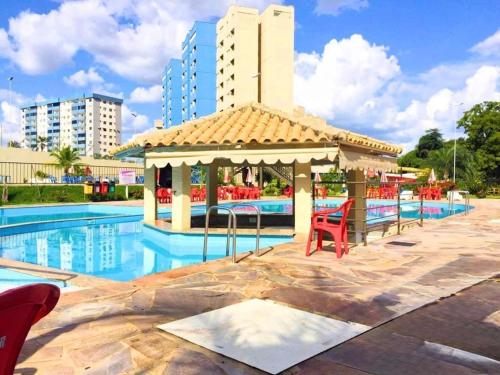 a swimming pool with a gazebo next to a building at No GOLDEN DOLPHIN EXPRESS VOCÊ IRÁ TER MOMENTOS ESPETACULARES! in Caldas Novas