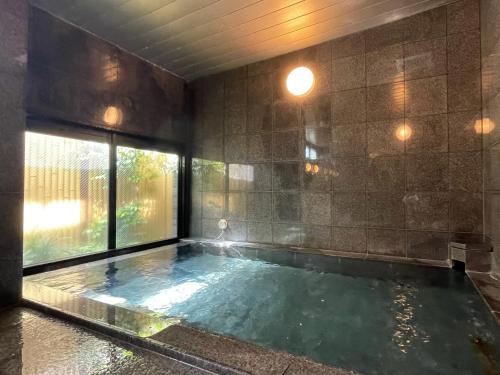 a large swimming pool in a room with a window at Hotel Route-Inn Saga Ekimae in Saga
