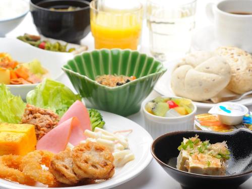 a table with plates of food and bowls of food at Hotel Route-Inn Saga Ekimae in Saga
