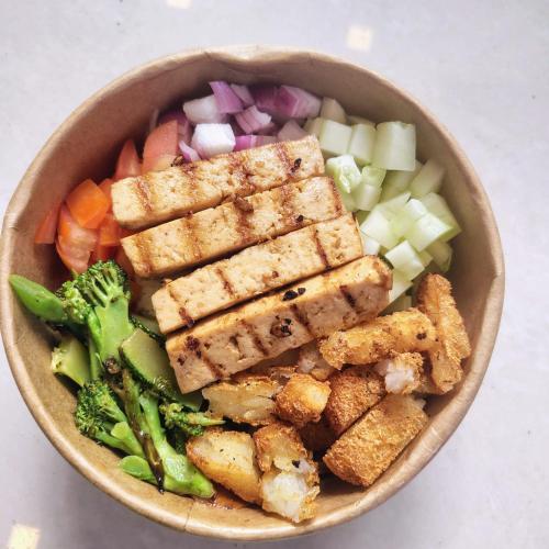 a bowl of food with tofu and vegetables on a table at MoonBasa Boutique Hotel and Spa Infopark , Kakkanad in Cochin