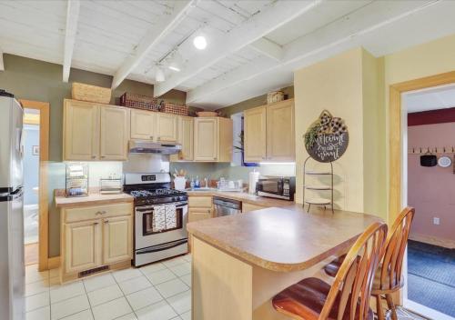 a kitchen with wooden cabinets and a table and a refrigerator at Historic Downtown Gettysburg Gem in Gettysburg