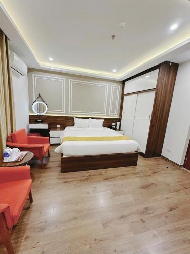 a bedroom with a bed and a desk and chairs at Hotel Villa Ju in Hanoi