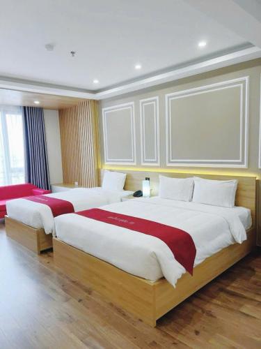 two beds in a hotel room with two bedsskirts at Hotel Villa Ju in Hanoi