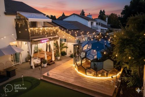 ein Haus mit einer Terrasse in der Nacht mit Lichtern in der Unterkunft Elegant Retreat- Sleep 10-Boho Dome Lounge-Hot Tub-Games-Golf-Serene Getaway in Sacramento