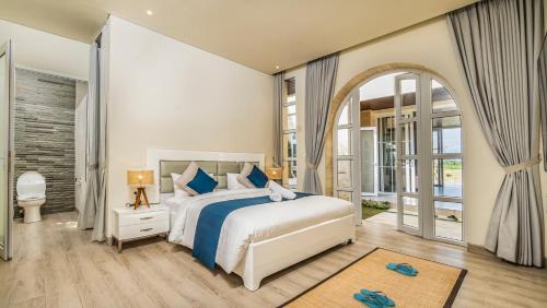 a bedroom with a bed and a large window at Villa Luna in Blahbatu