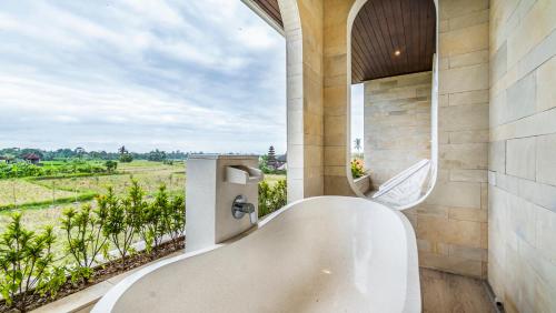 a bath tub in a bathroom with a view at Villa Luna in Blahbatu