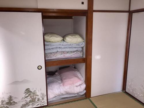 Habitación con armario y una pila de toallas. en D-pdal Inn 1F - Vacation STAY 14134, en Tokio