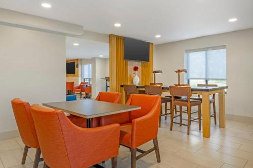 a dining room with orange chairs and a table at Holiday Inn Express - Plattsburgh by IHG in Plattsburgh