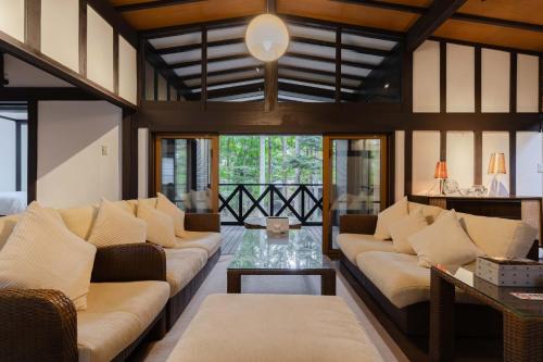 a living room with couches and a table at T&A Resort&Sauna KARUIZAWA in Miyota