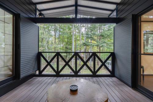 a room with a table and a large window at T&A Resort&Sauna KARUIZAWA in Miyota
