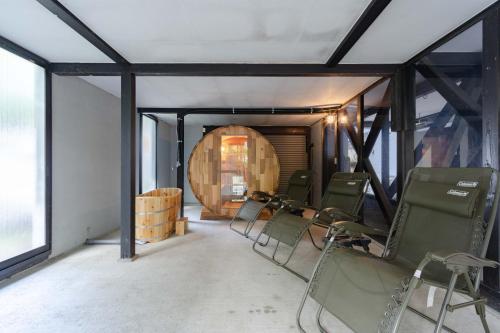a group of chairs in a room with a barrel at T&A Resort&Sauna KARUIZAWA in Miyota
