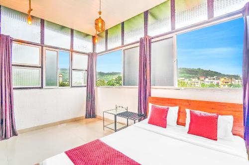 1 dormitorio con 2 camas y ventanas grandes en Villa Bliss by Palette Homes Lonavala, en Lonavala