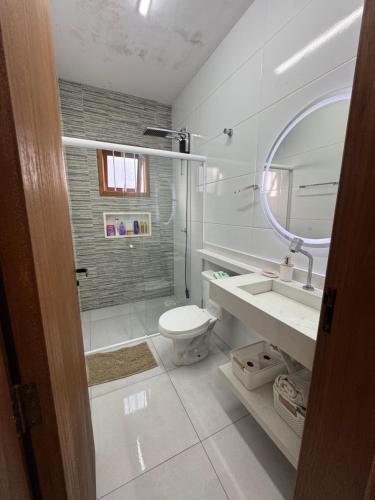 a bathroom with a toilet and a sink and a mirror at Casa na praia de Capão da Canoa in Capão da Canoa