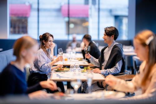 a group of people sitting at a table with wine glasses at The Gate Hotel Yokohama by Hulic in Yokohama