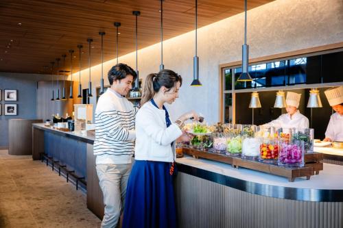 a man and a woman standing in front of a counter at The Gate Hotel Yokohama by Hulic in Yokohama