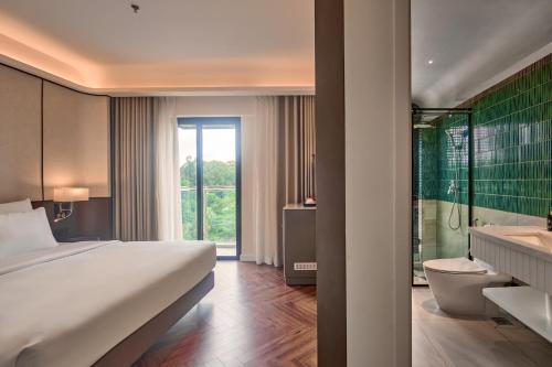 a hotel room with a bed and a tub and a bathroom at La Passion Saigon Hotel in Ho Chi Minh City