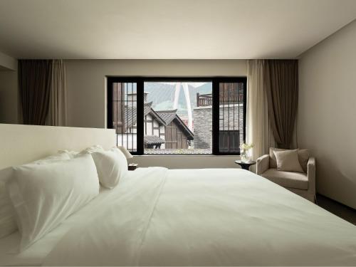 a bedroom with a large white bed and a window at Huguang Hidden Villa Hotel in Chongqing