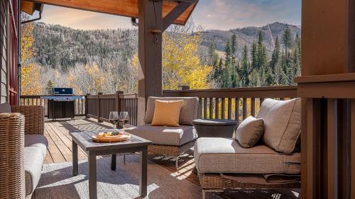 a screened in porch with two couches and a table at Orion Lodge in Steamboat Springs