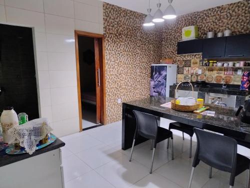 a kitchen with a counter and chairs in a room at Casa Temporada in Porto Seguro