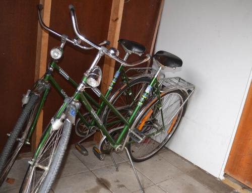 una bicicletta verde parcheggiata accanto a un muro di Ol-jons By a Hallen