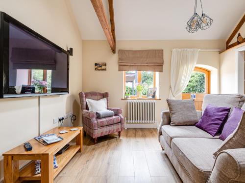 a living room with a couch and a tv at The Parlour - Uk10958 in Burlton