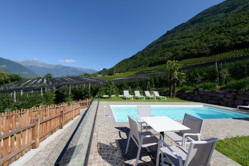 a patio with a table and chairs next to a pool at Moar Lodge in Postal