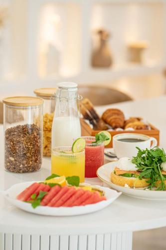 ein Tisch mit Tellern voller Essen und Getränke in der Unterkunft Mazari Villas in Uluwatu